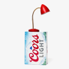 A red lamp placed on top of a Coors Light beer case against a white background.
